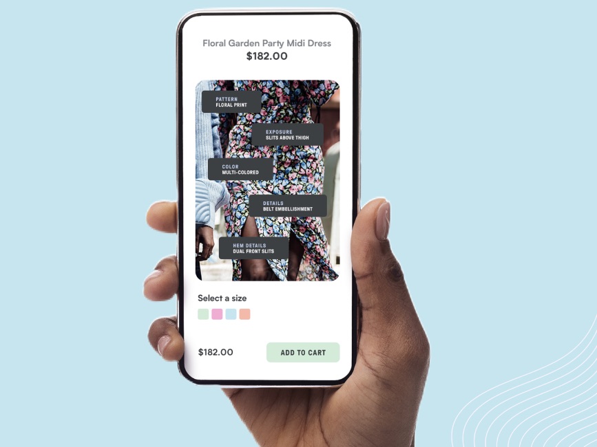 A hand holding a phone showing a floral dress product page with attribute tags.